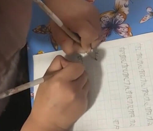 Школьница делает домашние задания двумя руками одновременно