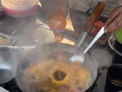 Торговец готовит быстрорастворимую лапшу, добавляя в неё апельсиновую газировку