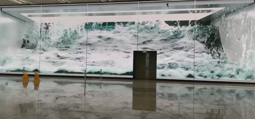 Бушующие волны на стенах станции метро как будто переносят пассажиров на берег океана