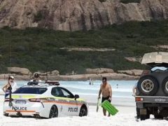 Полицейская машина застряла в песке на пляже