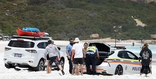 Полицейская машина застряла в песке на пляже