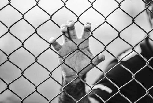 Больной одинокий мужчина разместился у ворот тюрьмы, умоляя, чтобы его впустили внутрь