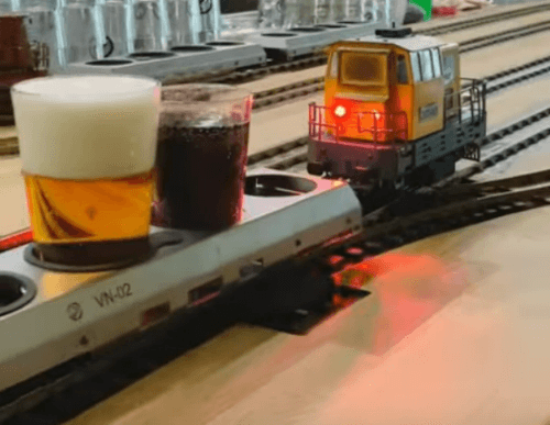 Игрушечный поезд доставляет еду и напитки посетителям ресторана